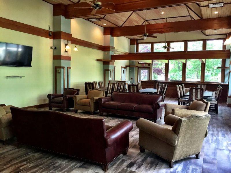 Enlightened Solutions living room/dining room is furnished with big leather couches and long wooden family style tables. The lighting and sound of the fountains on the walls provide a peaceful and comfortable atmosphere.