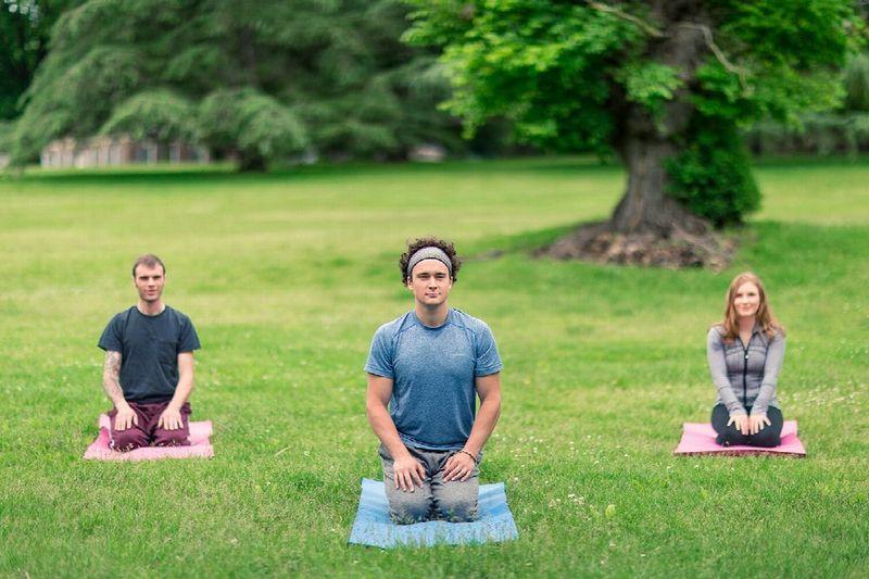 3 people doing yoga outdoors during their rehab stay